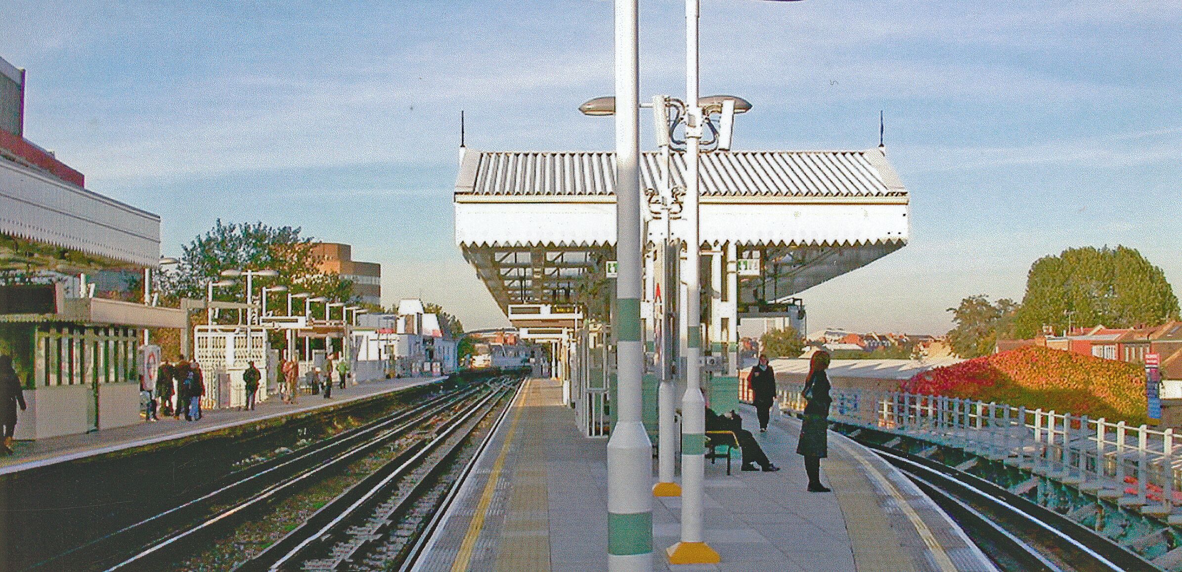 Putney Bridge Station, looking towards Earls Court. View northward, towards Earls Court etc.: London Underground District Line from Wimbledon. A London-bound train is disappearing from the Up platform (No. 1) and strangely enough, the middle platform (No. 2) is a bay.