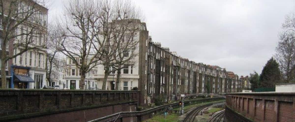 Tube Tracks View of the District & Piccadilly tube lines between West Ken and Barons Court stations. Looking west from the North End Road. The housing to the left is on Barons Court Road.