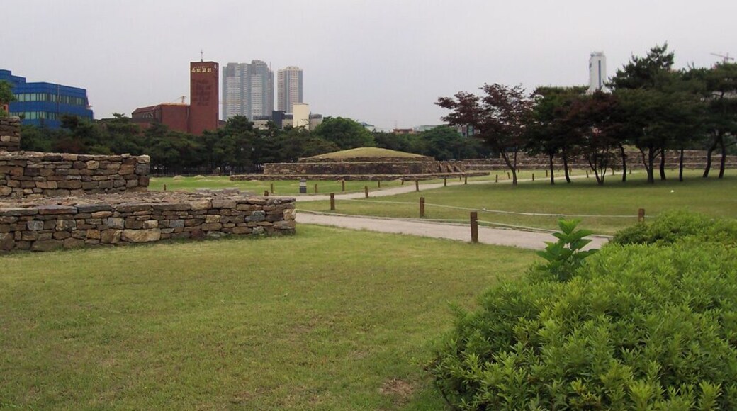 Several tombs located just south of Jamsil. These belong to the Baekje Kingdom, which ruled approximately the western half of modern-day South Korea from 18 BC to 660. Baekje's first capital was located in this general area, and there is another tomb complex about a mile to the northeast. These tombs used to be in a state of decay, with the complex bisected by a modern boulevard, as archaeology was an unaffordable luxury until the 1970s. But in the 1980s, excavation and restoration took place, and the boulevard was put through an underground tunnel. Further away I can see the modern developments that mark today's Seoul: a Protestant church, three high-rise condominium buildings, and Hotel Lotte World. Jamsil area would gain dozens more high-rise condominiums over the next few years.