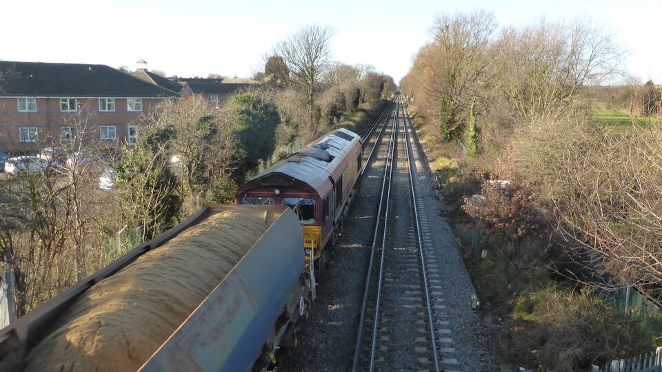 Class 66 (JT42CWR) number 66160 built by General Motors Electro-Motive Division, London, Ontario, Canada in 1999 and unloaded from the Heavy Lift Ship MV Fairmast at Newport Docks on 19 October 1999 seen here in EWS livery with the Angerstein Wharf Tarmac to Acton T.C. freight train 693V on 19 December 2013
