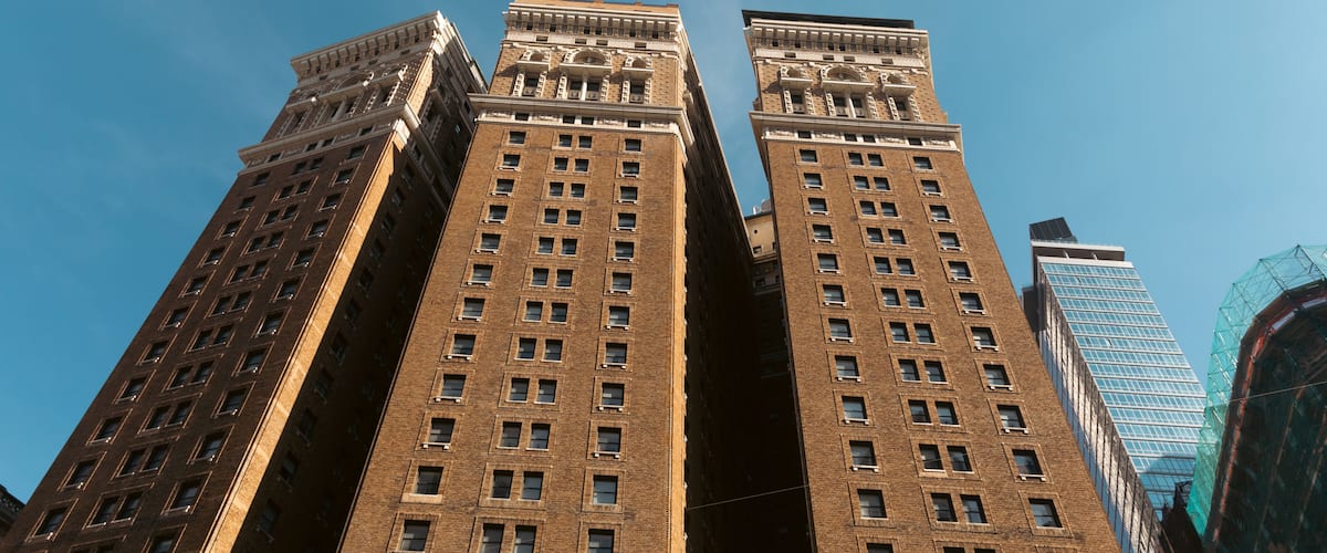 A tall, brown brick building with a clear blue sky in the background.