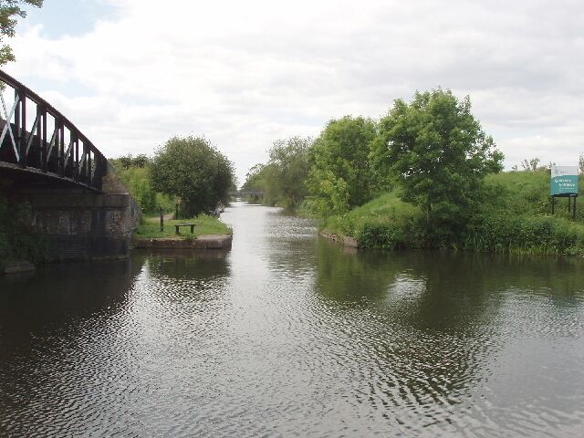 Bridge to Slough Arm, Grand Union Canal. The footbridge gives access from the towpath of the Grand Union Canal to that along its Slough Arm, straight ahead in the photo. See 422229 for a view in January 1977 - mainly different in this spring photo with leaves on the trees looking more pleasant than the earlier one in winter with bare branches.