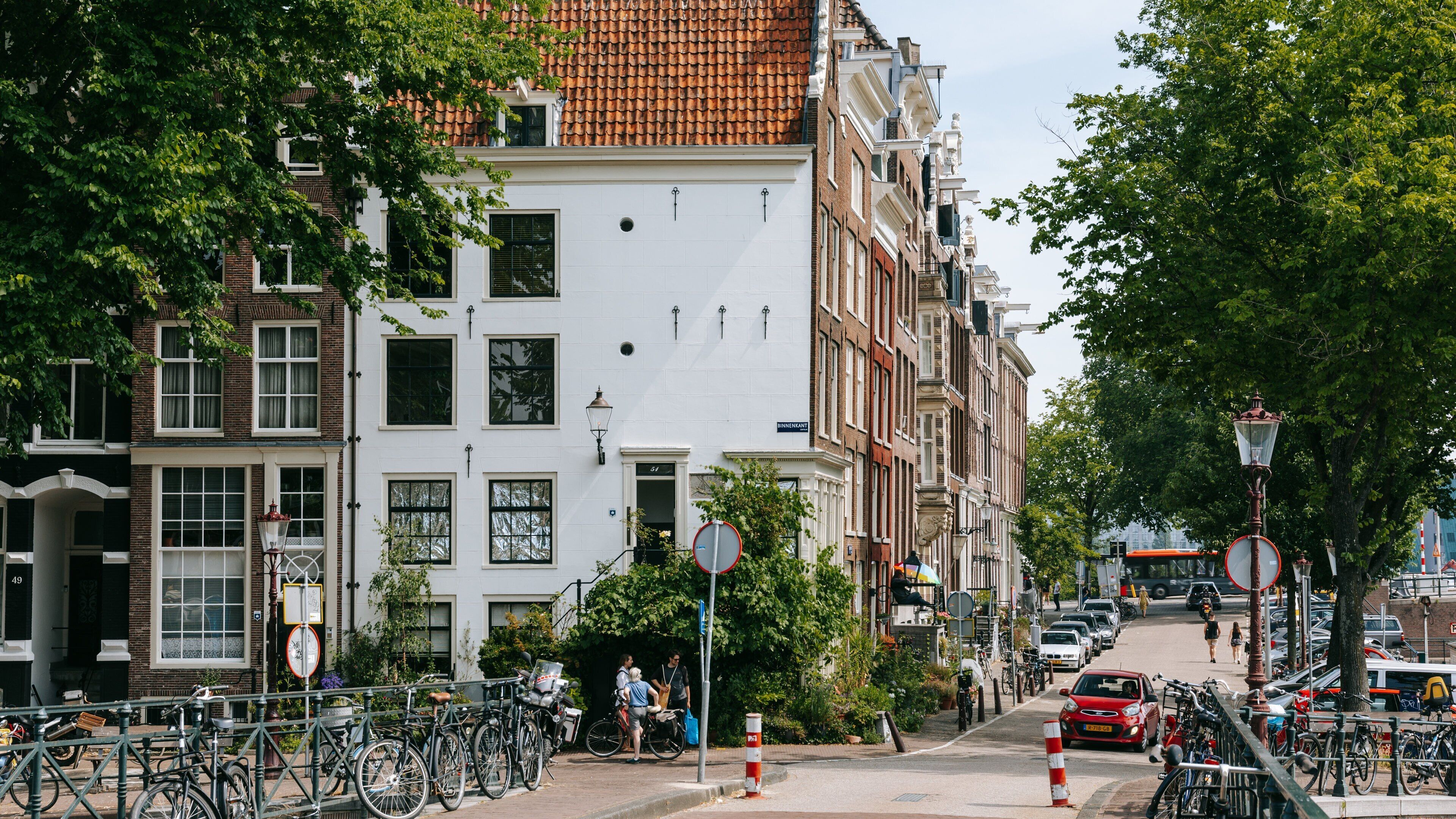 A street lined with historic buildings, bicycles, and pedestrians.