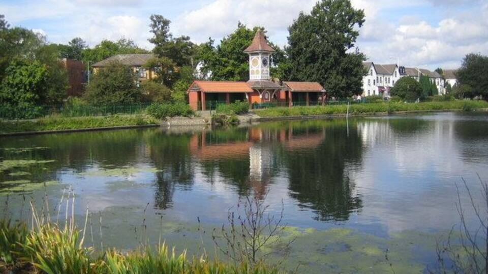 Cranbrook: Valentines Park clock tower This view was taken looking across the boating lake in Valentines Park towards the clock tower, which was built in 1899 on the opening of the park. A plaque on the clock tower commemorates that it was presented by W. P. Griggs Esq. At its opening the park was known as Cranbrook Park, as witnessed by the plaque, but the name was changed in 1907 to register its association with the nearby Valentines Mansion.
