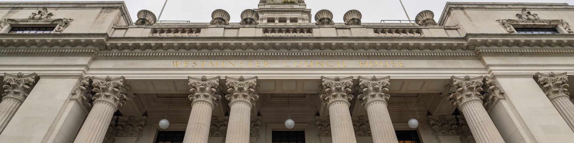 Le bĂątiment du conseil municipal de Westminster se distingue par son architecture classique, notamment ses colonnes corinthiennes et son fronton triangulaire.