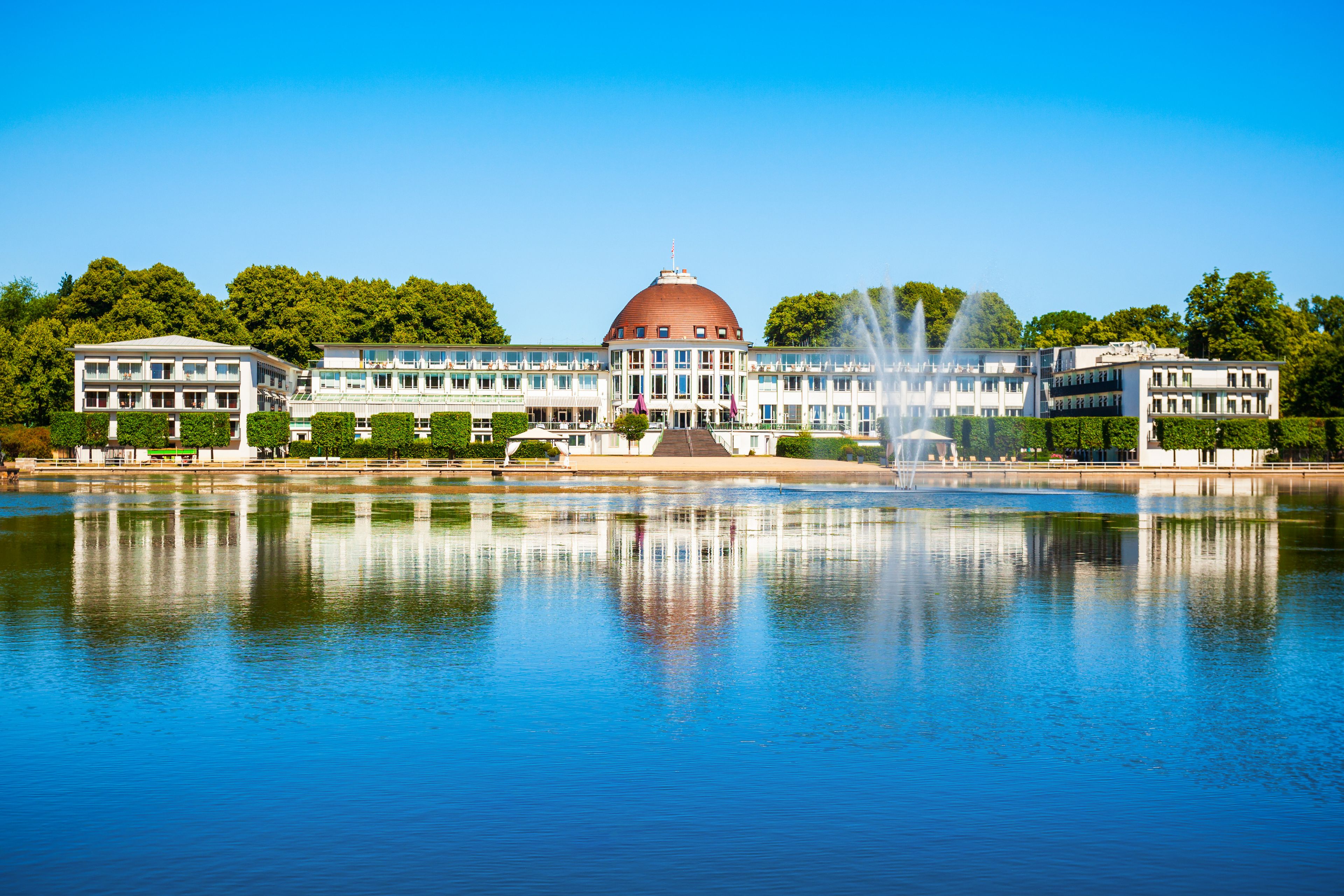 A large building with a prominent dome, reflecting in a calm body of water.