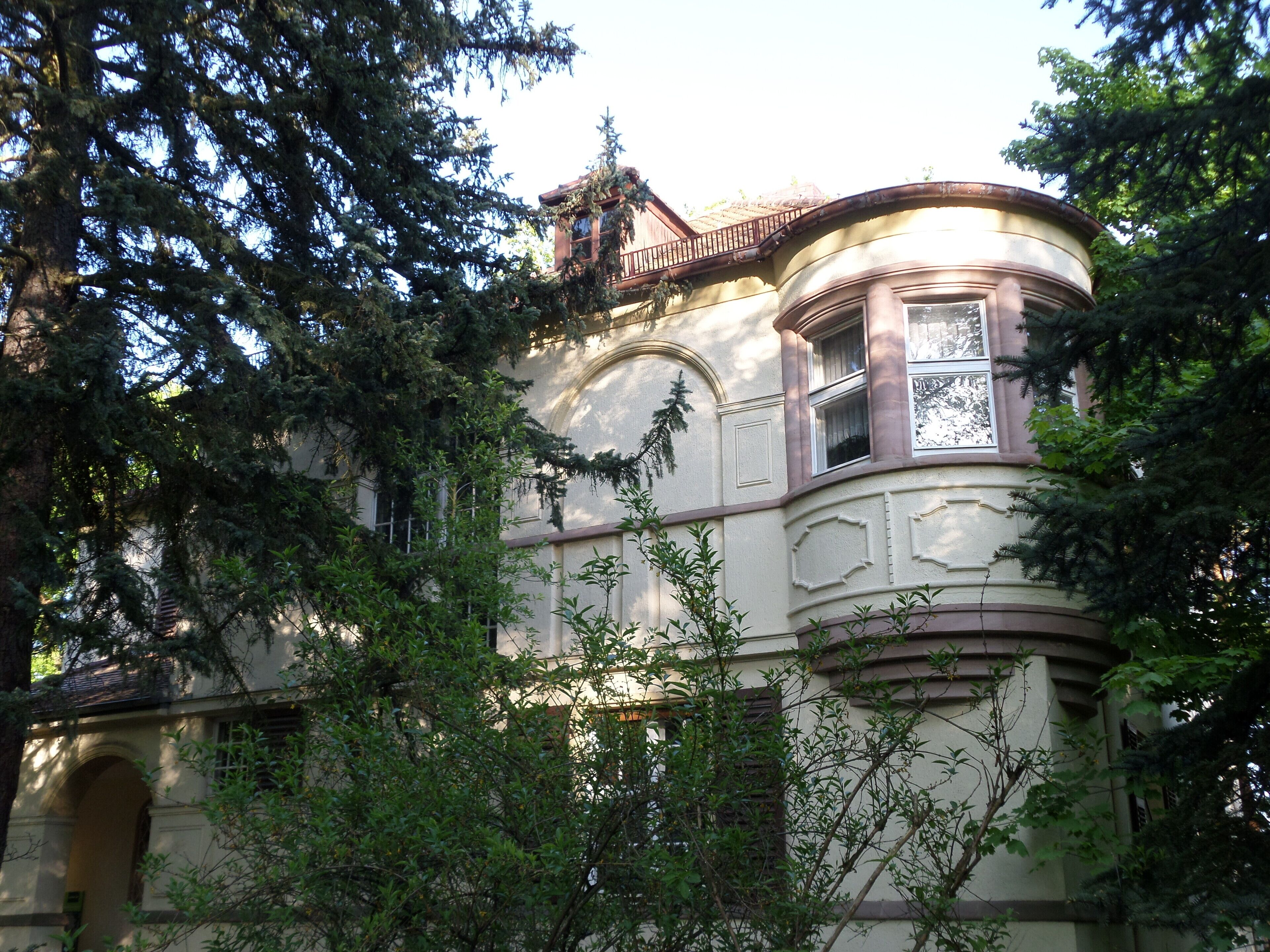 A historic building with ornate architecture, surrounded by lush greenery.