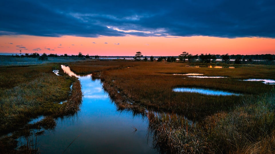 Dramatic twilight seascape over the marshland river at South Cape Beach in Mashpee, Massachusetts.