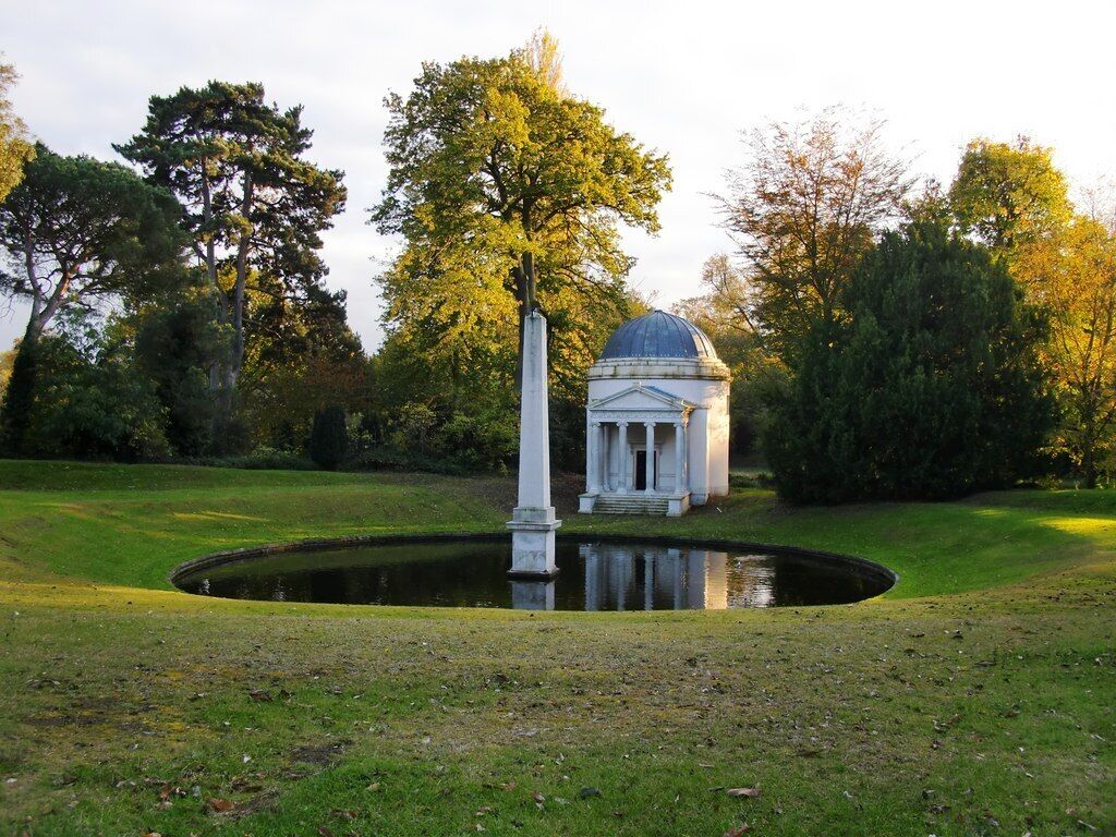 The Ionic Temple, Obelisk and Mirror Pond, Chiswick House Chiswick House as we know it was the brainchild of the 3rd Lord Burlington (1694-1753), and though both house and gardens have had to survive periods of neglect, the overall scheme - following restoration work in the last half-century - remains essentially his. According to Colen Campbell's 'Vitruvius Britannicus' (published in the 1720s) the little building shown here - which Campbell called 'bagno' (Italian for bath-house) - was Lord Burlington's first architectural project, dating from 1717. In the years which followed, Burlington - assisted by William Kent - went on to produce the design for the house itself. (Source: the Middlesex volume of Pevsner's 'The Buildings of England'.)
