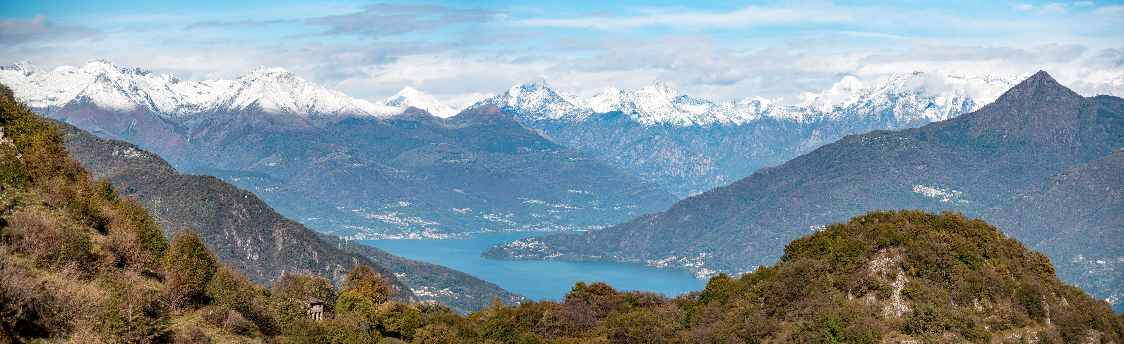 A mountainous landscape with a lake and snow-capped peaks.