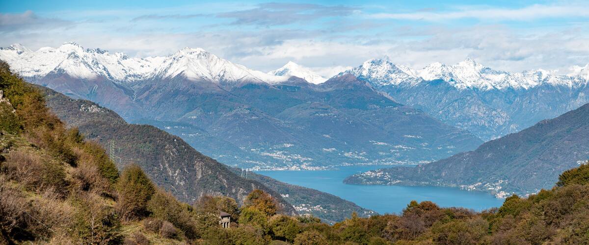 A mountainous landscape with a lake and snow-capped peaks.