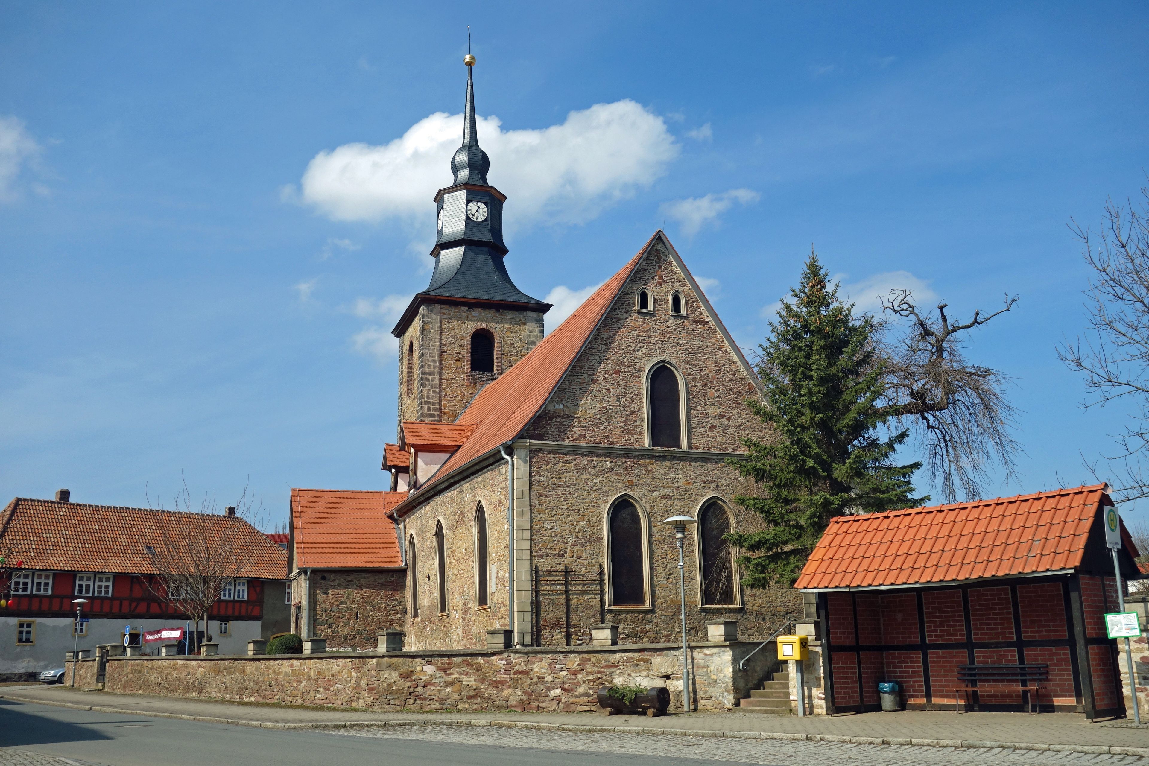 Eine Kirche mit einem hohen Kirchturm und einem Glockenturm.