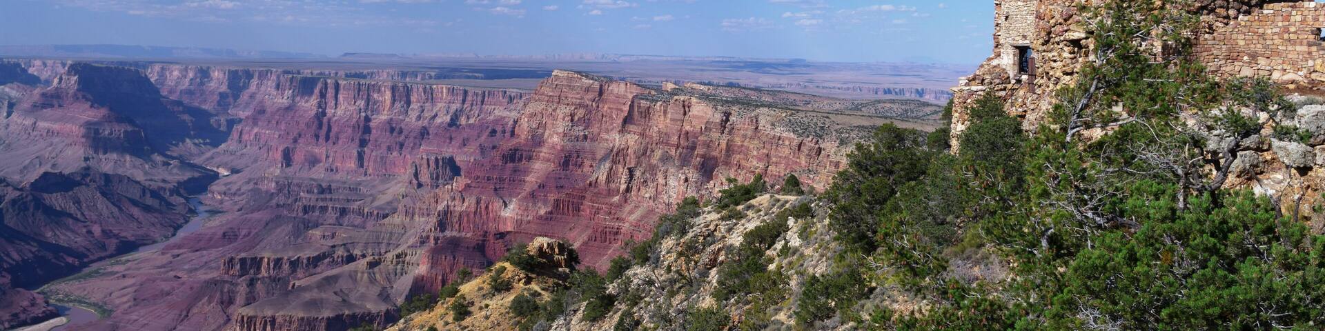 A tall stone tower with a clear view of the Grand Canyon in the background.