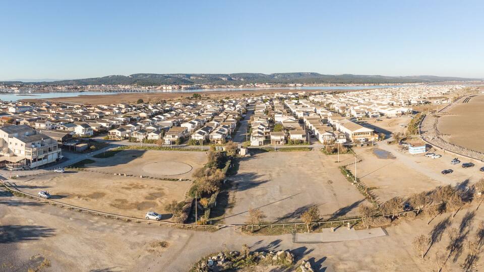 An aerial view of a coastal town with a river, beach, and residential area.