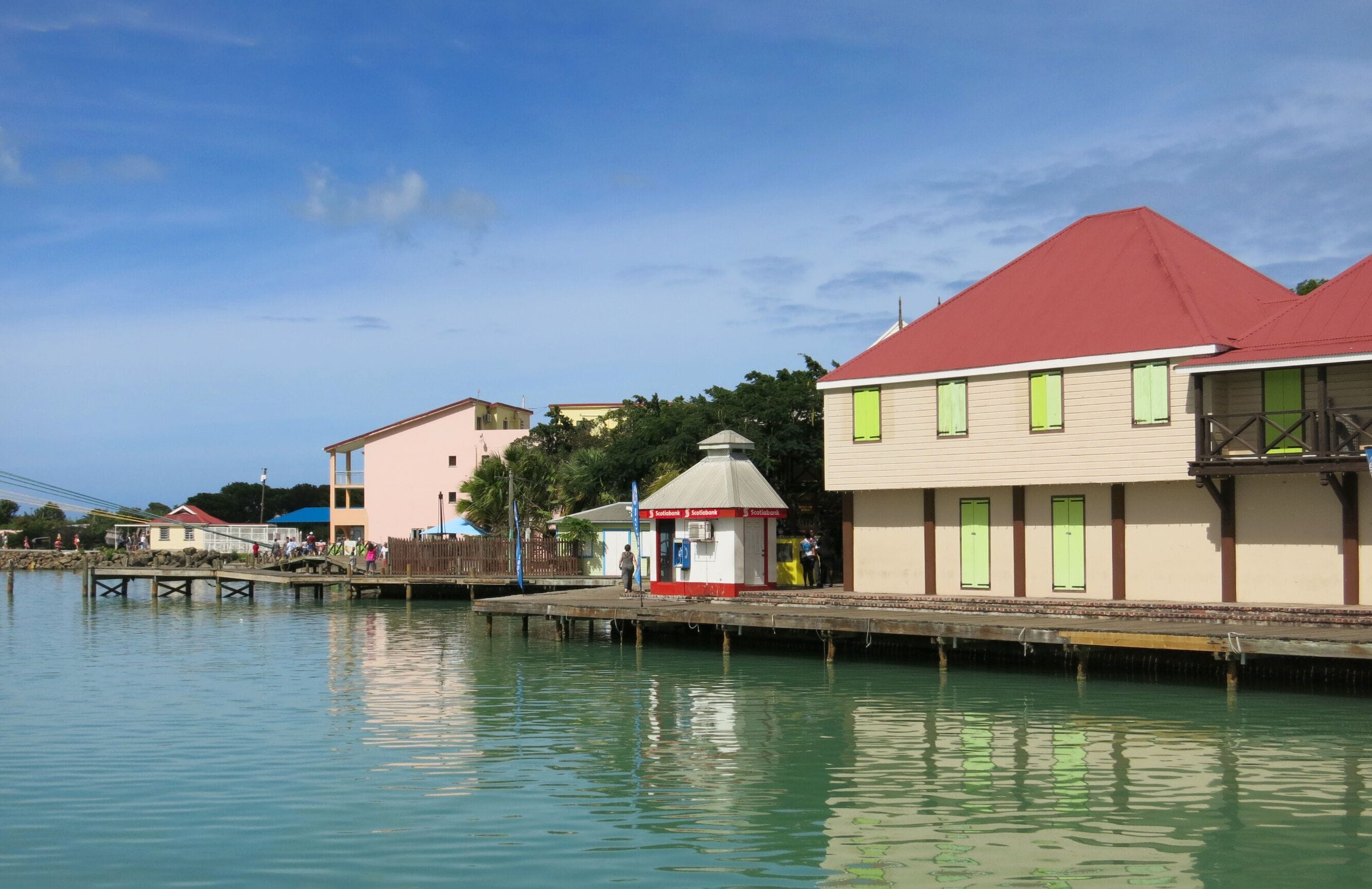 A waterfront with buildings, a dock, and a small kiosk.