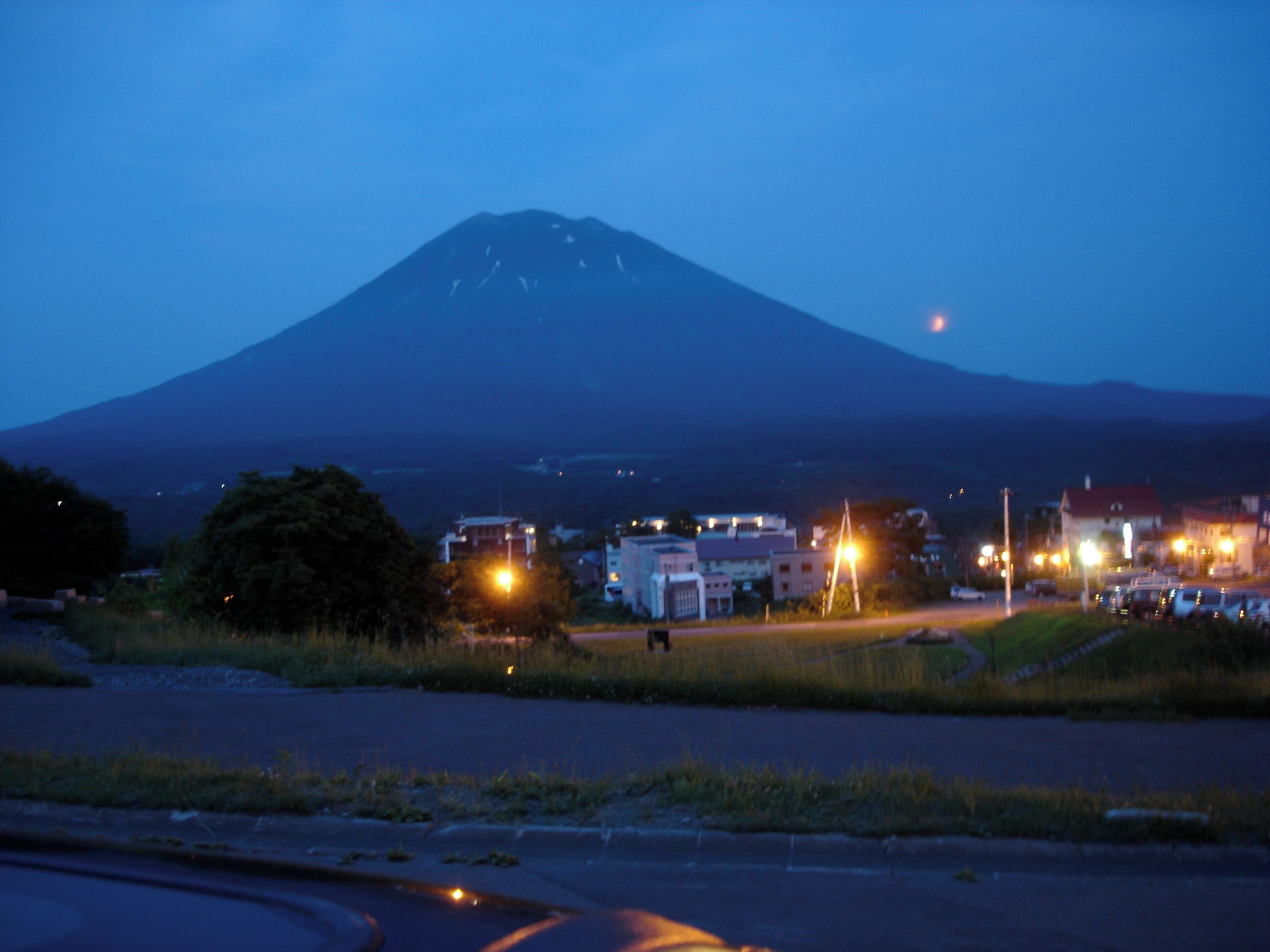 A mountain at dusk with a small town in the foreground.