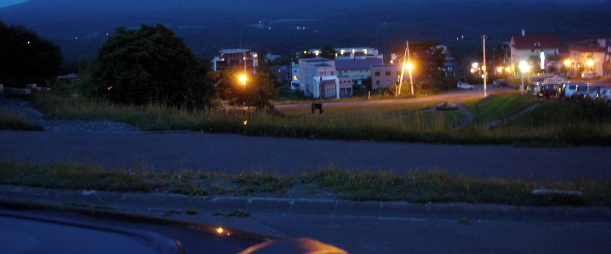 A mountain at dusk with a small town in the foreground.