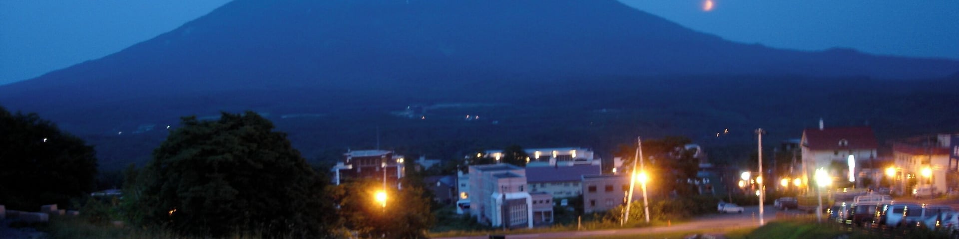 A mountain at dusk with a small town in the foreground.