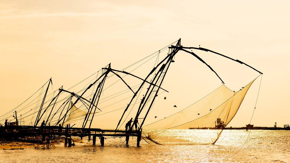 Panoramic silhouette of chinese fishnets on sunset at Fort Kochi, Kerala, India.