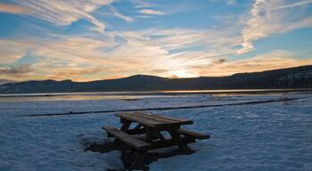 Picnic bench surrounded by snow at sunset in Lake Tahoe, California.