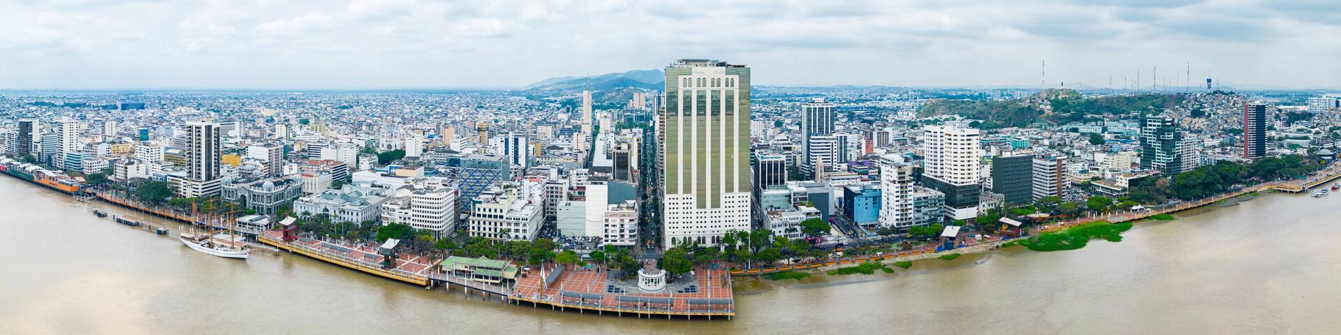 A cityscape with a prominent skyscraper, a river, and a bridge.