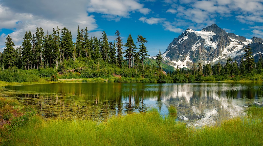Cordillera de montañas con un lago en primer plano.