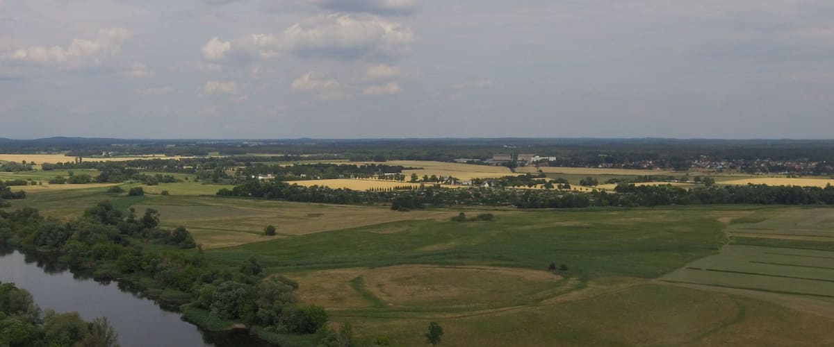 A river winding through a rural landscape with fields and scattered buildings.