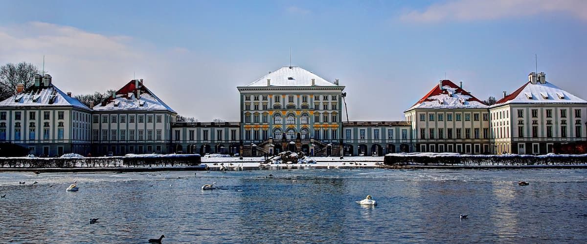 A historic building complex with snow-covered roofs and a central building with a dome.