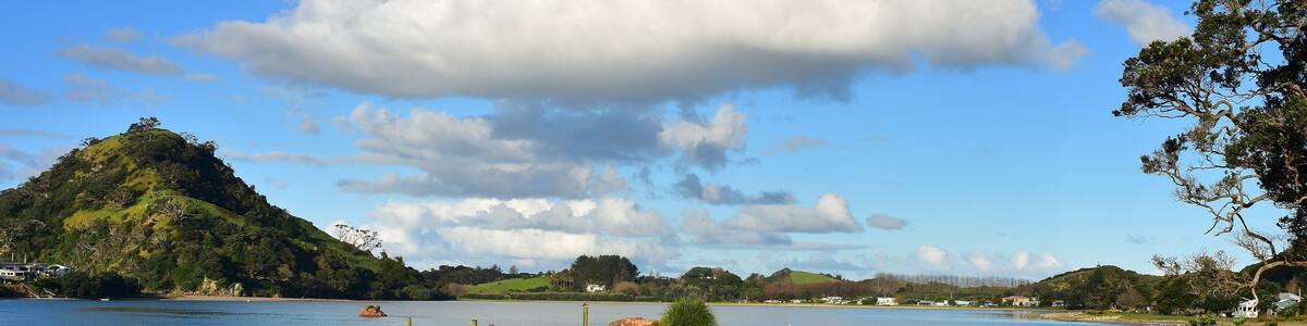Stone wharf in Pataua River estuary from Pataua North with island in background. Location: Pataua North New Zealand