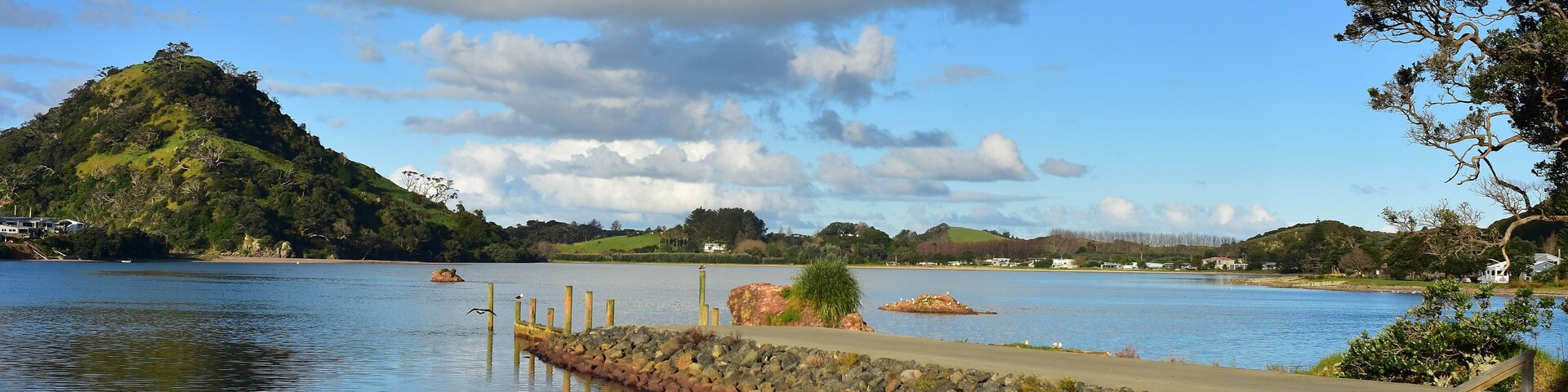 Stone wharf in Pataua River estuary from Pataua North with island in background. Location: Pataua North New Zealand