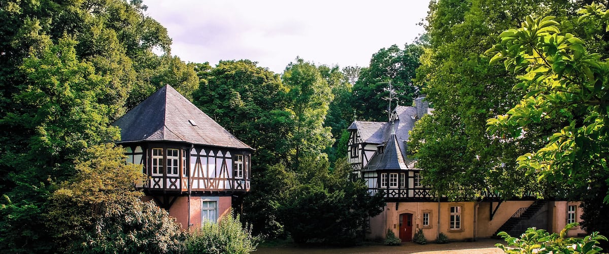 Mittelalterliche Wasserburg, die im neunzehnten Jahrhundert durch Luise Prinzessin von Preußen zum Schloss mit englischen Park umgestalltet
