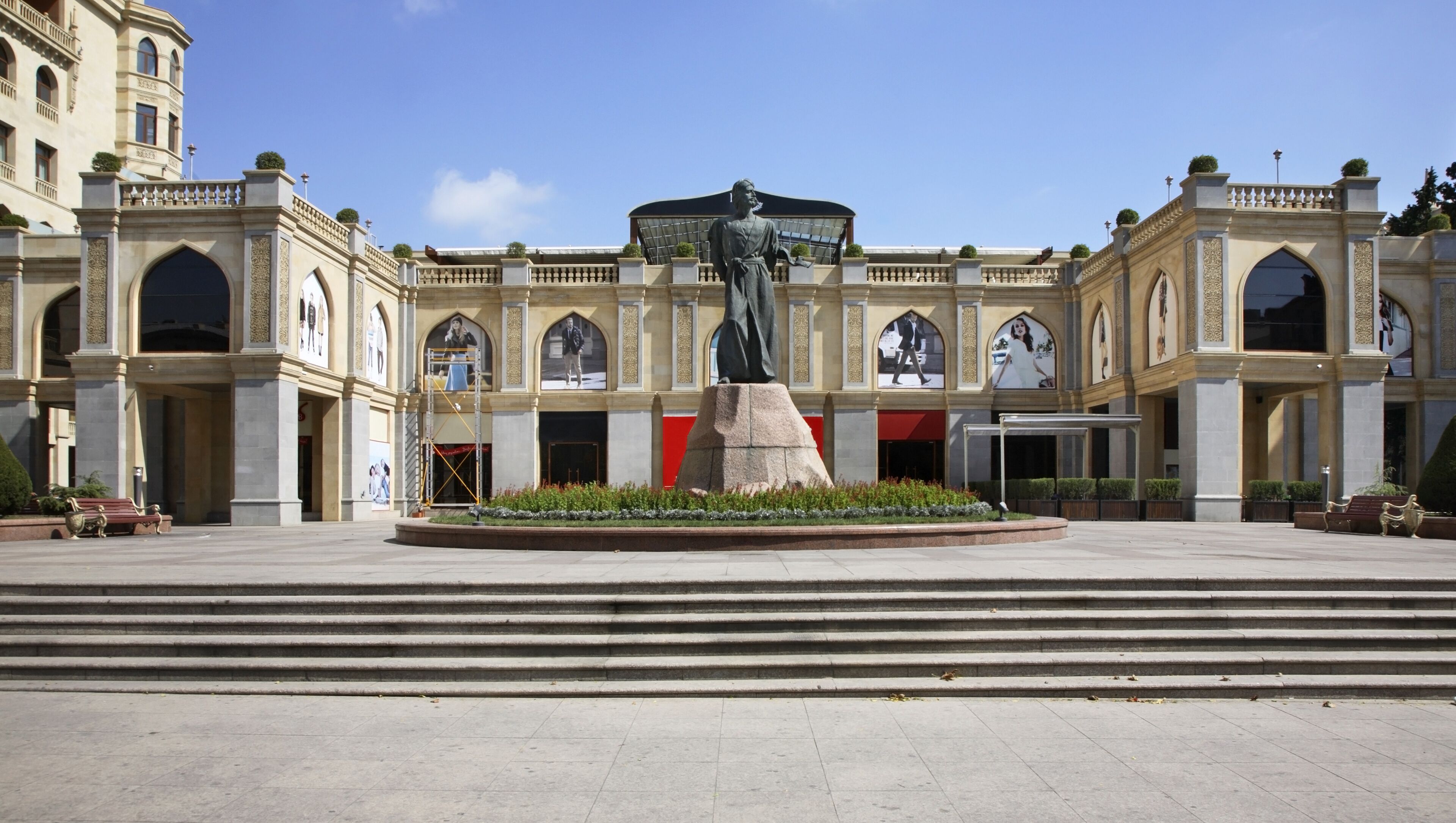 A grand building with a central statue, arched windows, and a large entrance.