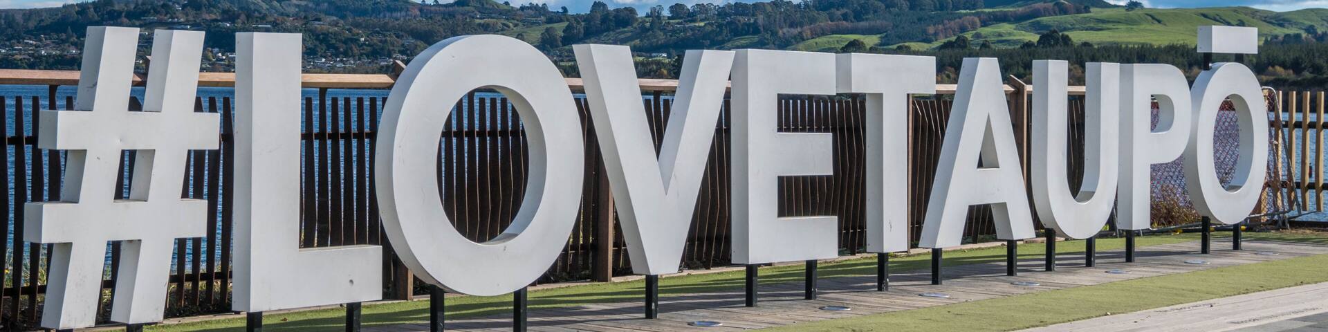 A large outdoor sign with the hashtag #LOVETAUPO.