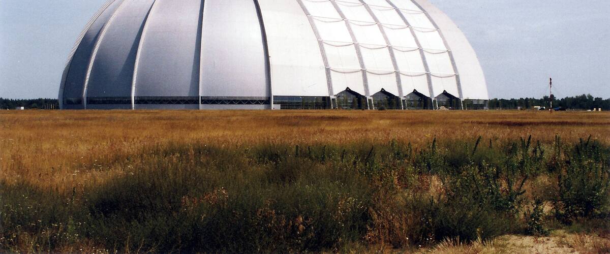 Ein großes, weißes, kuppelartiges Gebäude in einer Wiese.