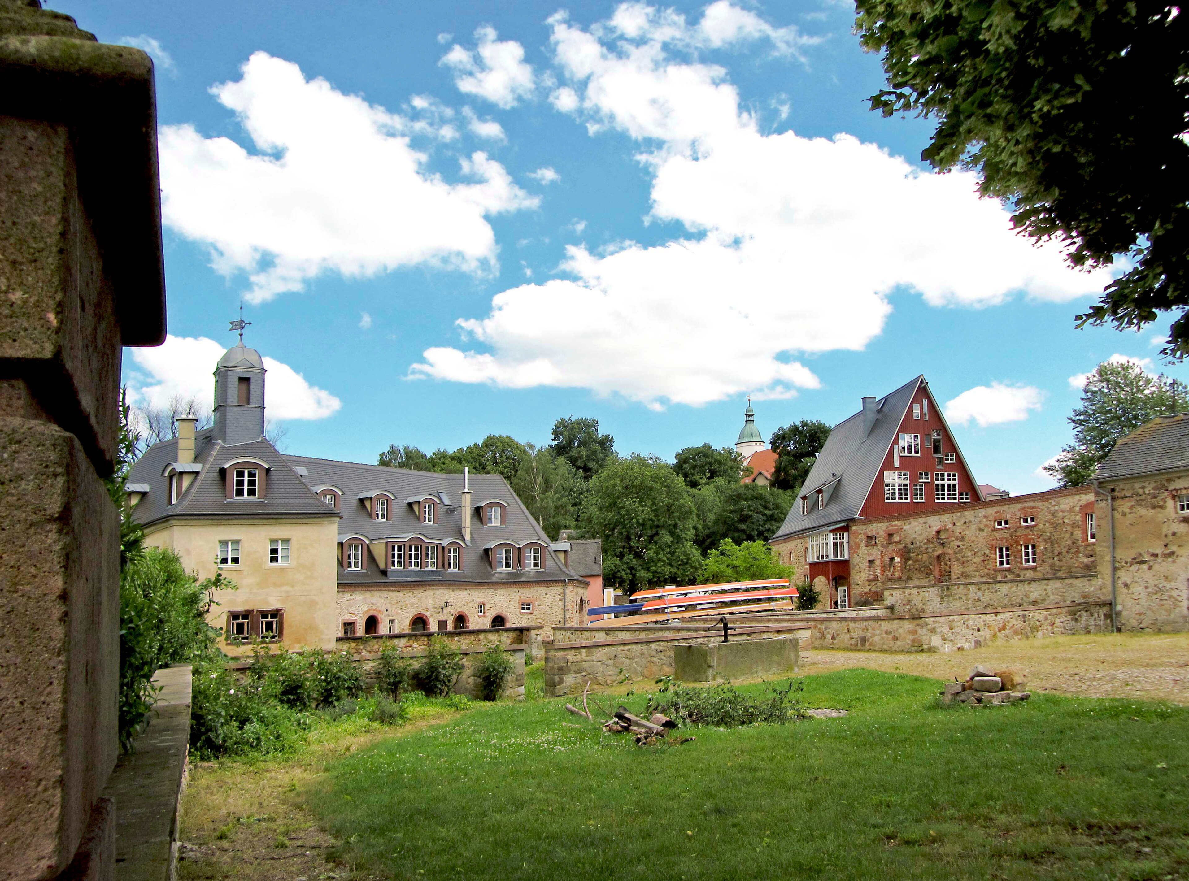 A historic town with stone buildings, a church with a steeple, and a train in the background.