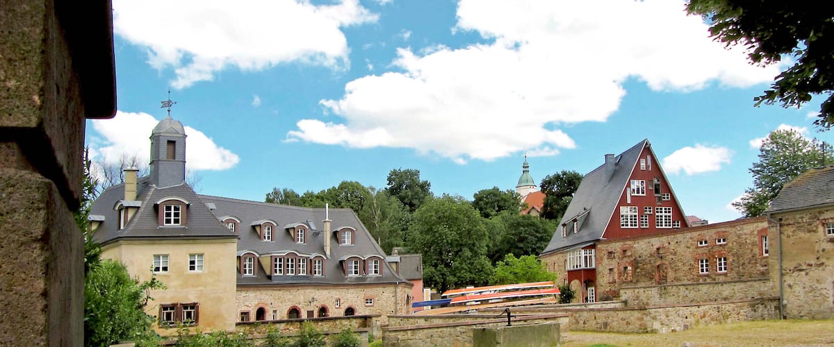 A historic town with stone buildings, a church with a steeple, and a train in the background.