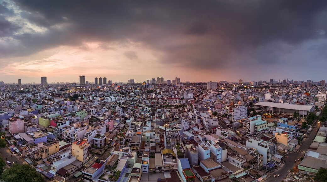 Urban density along canal. Dramatic aerial panorama of Ho Chi Minh City, Vietnam showing rooftops and skyline in evening light.