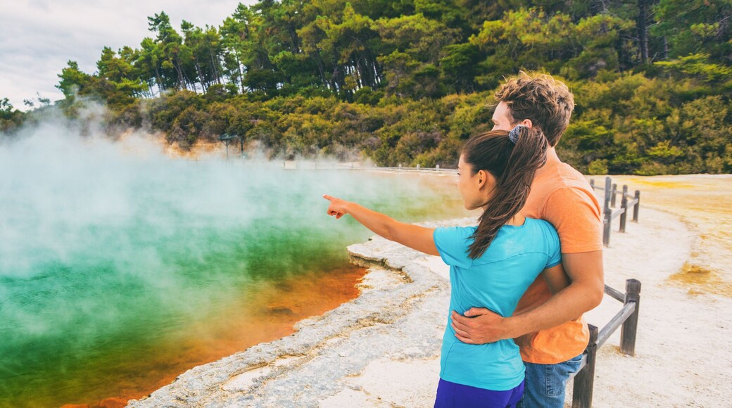 New Zealand travel tourists couple at Champagne pool at Wai-O-Tapu pools Sacred Waters. Tourist attraction in Waiotapu, Rotorua, north island. Panoramic banner, Okataina Volcanic Centre, Taupo.