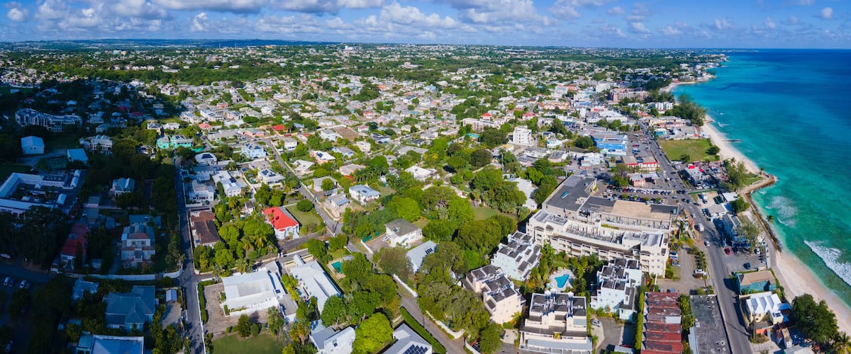 An aerial view of a coastal town with a beach, residential areas, and a mix of buildings.