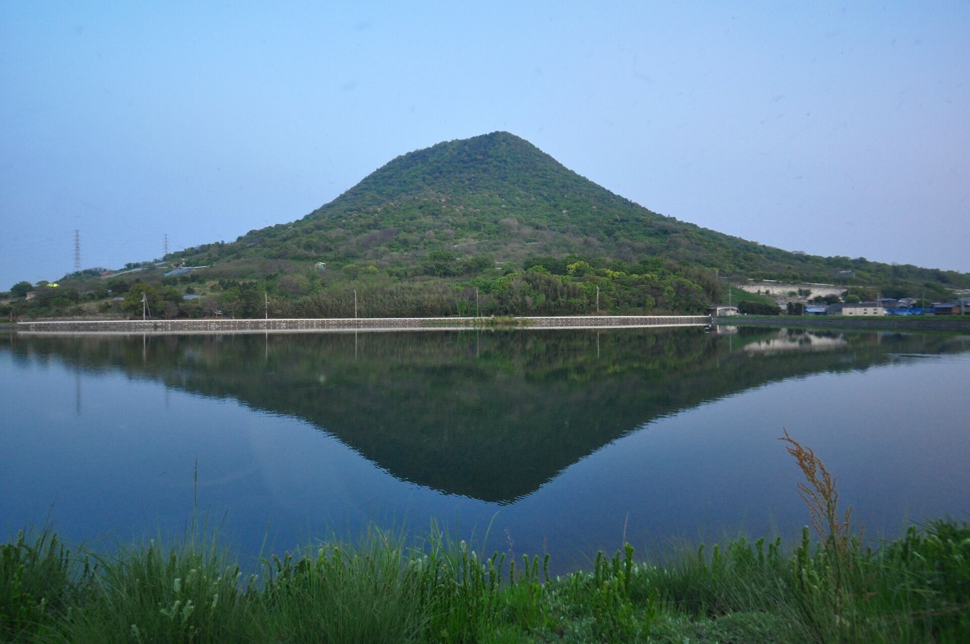 A calm lake with a mountain in the background.