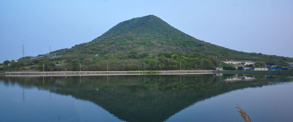 A calm lake with a mountain in the background.