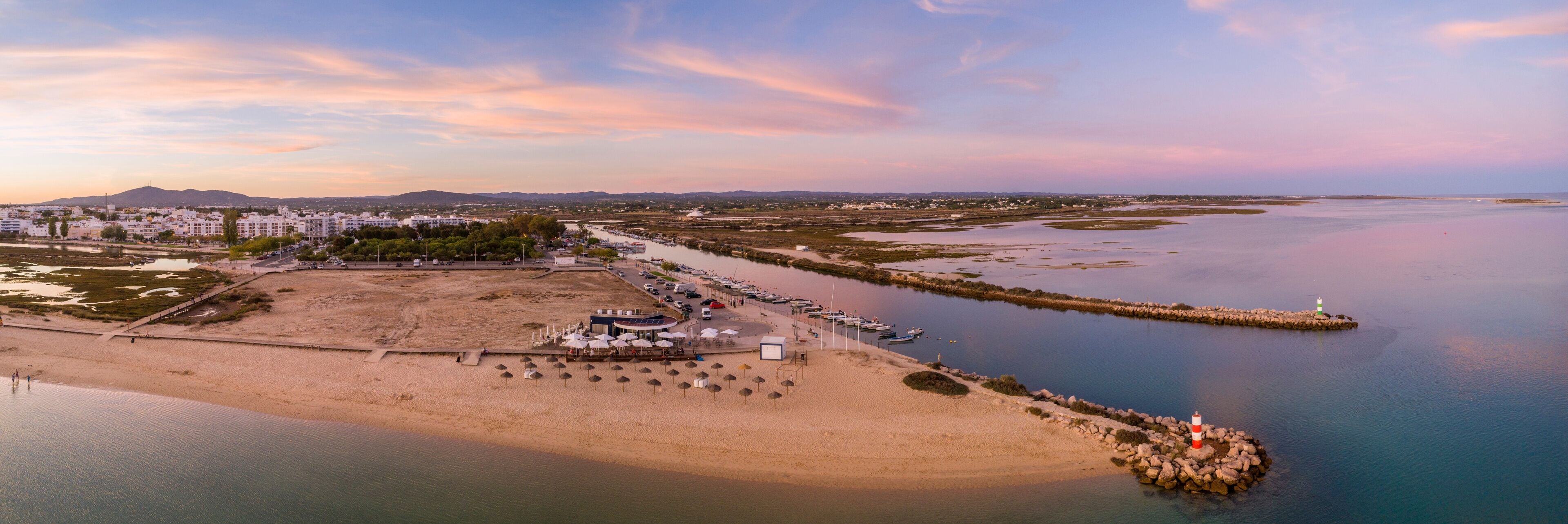 Aerial dusk panoramic view at Fuseta fishing town, in Ria Formosa wetlands nature conservation park, Algarve. Portugal.