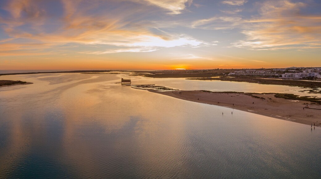 Aerial sunset and historic life-guard building at Fuseta fishing town, in Ria Formosa wetlands nature conservation park, Algarve. Portugal