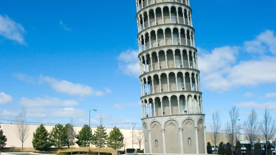 A spiral tower with a pool in front.