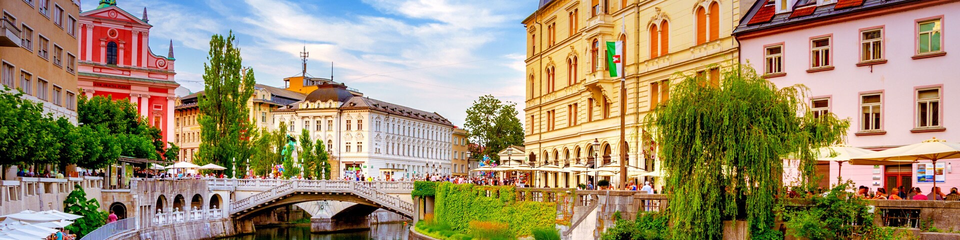 A river with a boat, a bridge, and historic buildings along the banks.