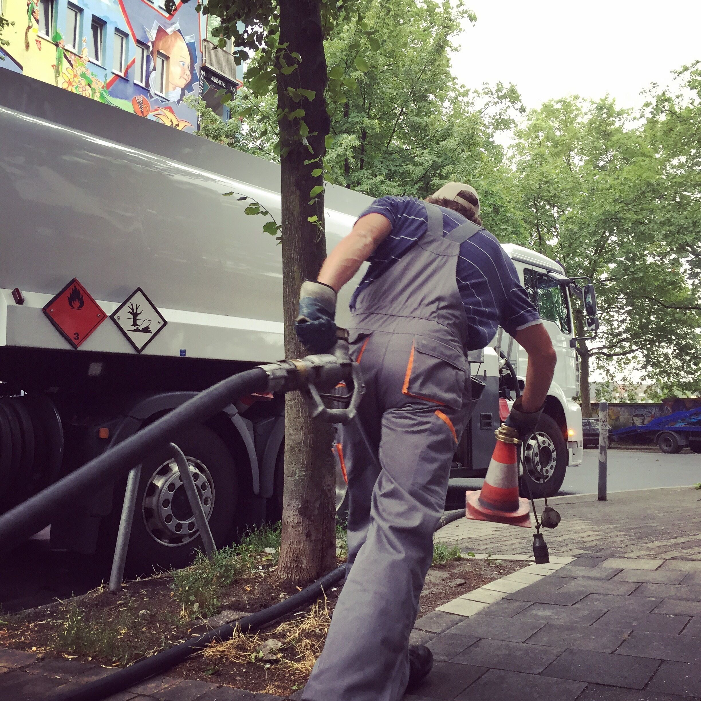 Back in the days, when #punkrock was still dangerous, the #Kiefernstraße in #Düsseldorf was an infamous street to walk on.

"Those days are long gone“, says Frank, the dude who delivers the heating diesel to a couple of houses on the block. I had offered him one of my genuine handcrafted Italian cappuccino to kickstart the conversation, but he’d declined with a broad smile across his face and countered, that he’d just finished his 20oz trucker coffeemug. That must’ve been the reason for him being so talkative, or maybe the fact that he’s riding by himself nowadays and the tenant who was supposed to sign the bill of delivery was a no-show. „you know, boy“ he said „back in the days when we would pull around the corner into this street people would be cheering us a welcome“. Ya right, I was trying to imagine how that must’ve looked like: a bunch of angry kids and young punks who haven’t slept in three days straight getting all happy for the diesel boys? 

Anywoo, Frank seemed to sense that doubt in my eyes so he added „when I rang the doorbell I had to watch my head because almost instantly someone would drop a rope down from a balcony above“. They pulled up the diesel hose to fill up two barrels large with the heating fuel. Frank explained that the second diesel boy meanwhile had to stay inside the delivery truck so it wouldn’t get stolen while he was hooking up the hose to the rope.

„Those days are long gone“ he repeated with an ambiguous smirk on his face. „When punk rock was still dangerous“, I thought. Nowadays the old folks live in regular tenancies and not much happens around here anymore. Except maybe neighbors calling the cops or fighting over music being played too damn loud or even arguing over paint being spilled all over the sidewalk and everywhere. I signed Franks delivery bill, took my cappuccino cup back inside my messy place and sighed as I dialed my doctors phonenumber. I’ve been wanting to talk to him about all this and what not. Just being alive and love to give. Thank God, I’m a cuntree boy. Yip, that’s meh.
