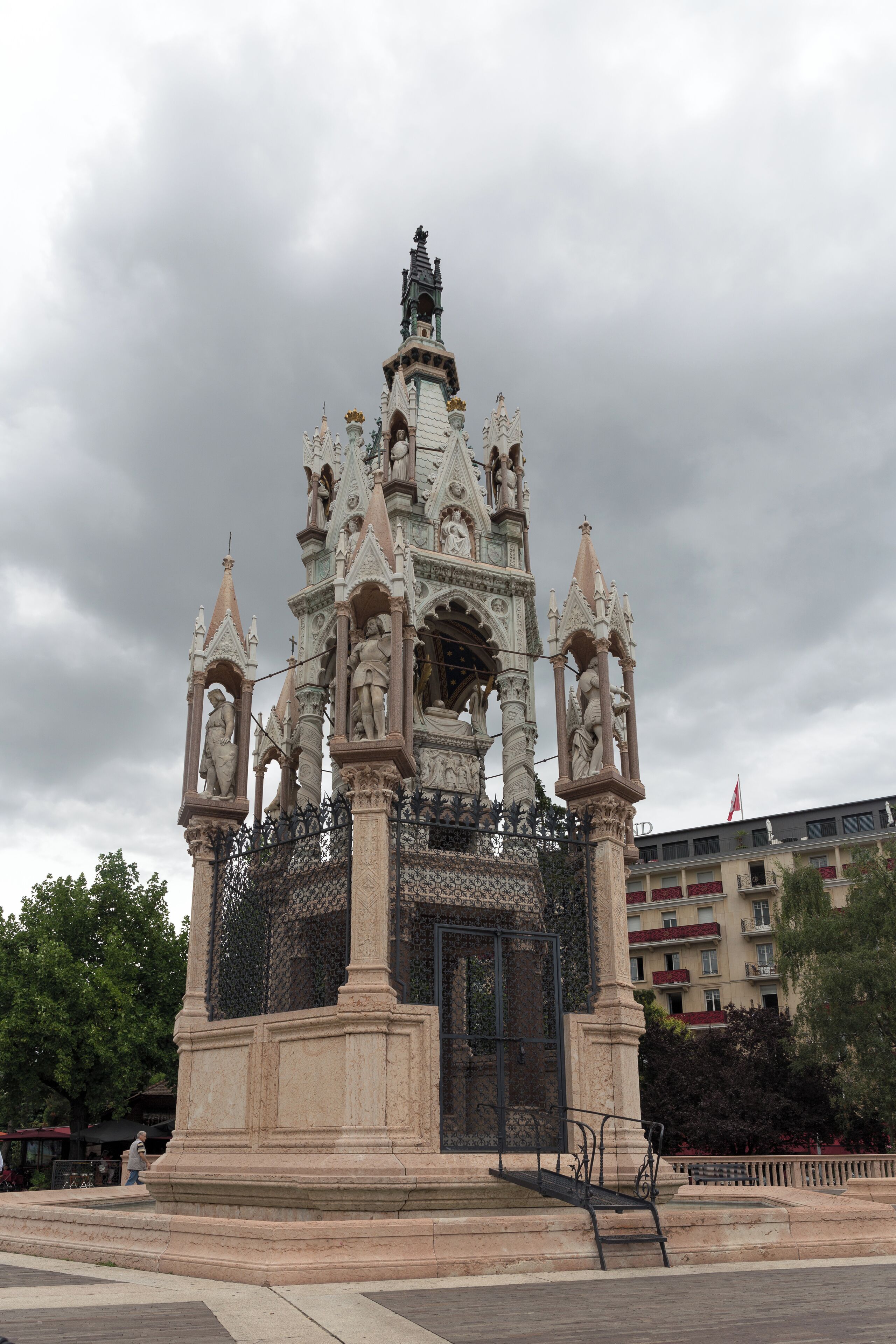 A Gothic-style monument with intricate carvings and statues, surrounded by a fence.