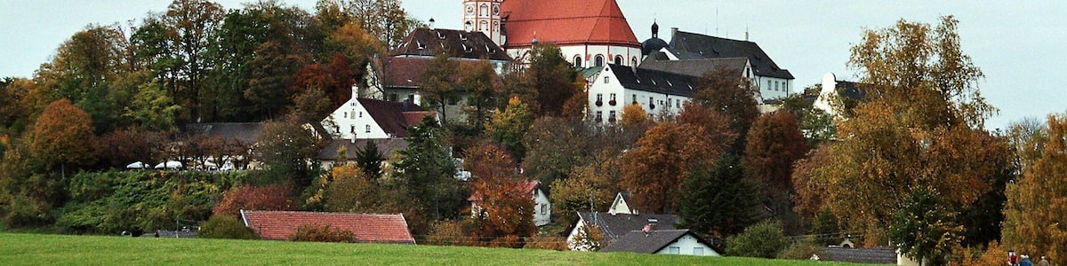Eine historische Stadt mit einem markanten Kirchturm und umliegenden Häusern.