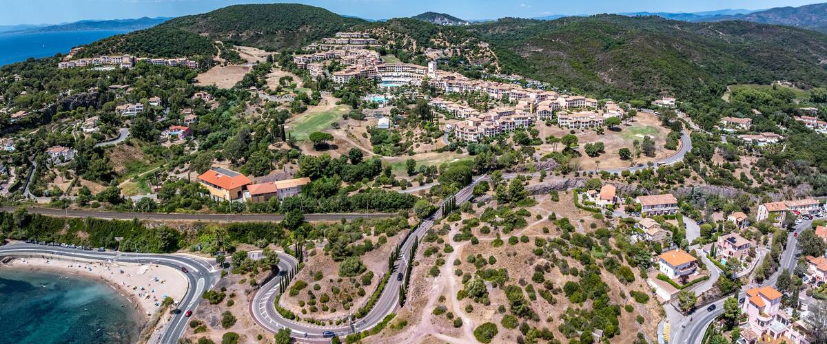 aerial landscape view of area around Village Cap Estérel in Saint-Raphaël, at Agay Bay, French Riviera (Côte d'Azur) with "Plage du Pourrousset" Beaches and wooded hilly landscape in background