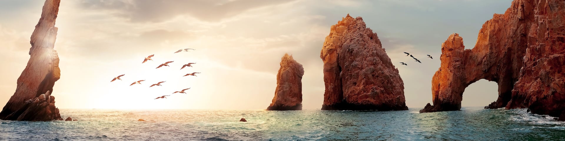 Rocky formations on a sunset background. Famous arches of Los Cabos. Mexico. Baja California Sur. Panoramic image. Banner format.